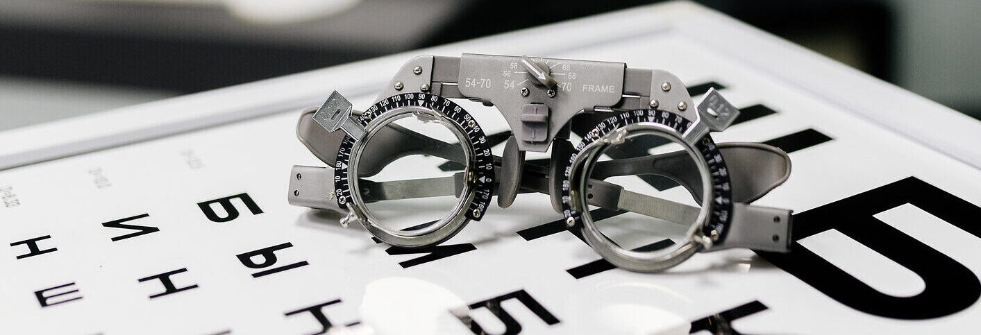 Image of test glasses with letter diagram for eye examination, vision optometry background. Vision diagnostics and prevention concept.